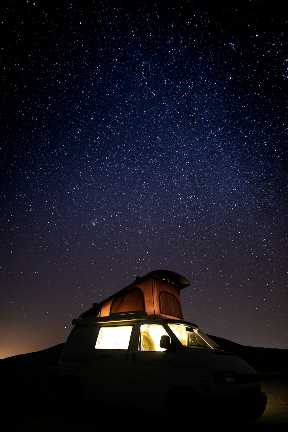 camper van under starry sky during nighttime