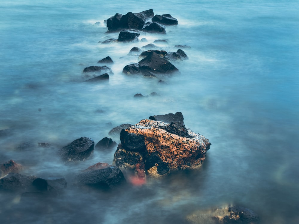 grey and brown rock covered in foggy water