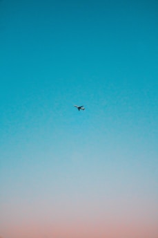 flying airplane under blue sky