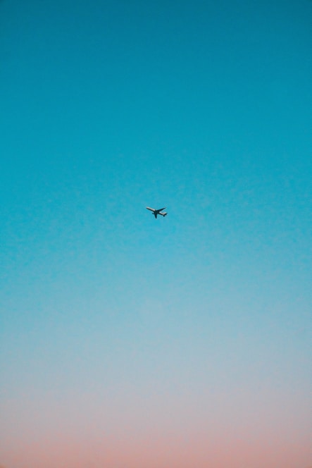 flying airplane under blue sky