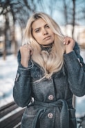 woman wearing gray trench coat in selective focus photography