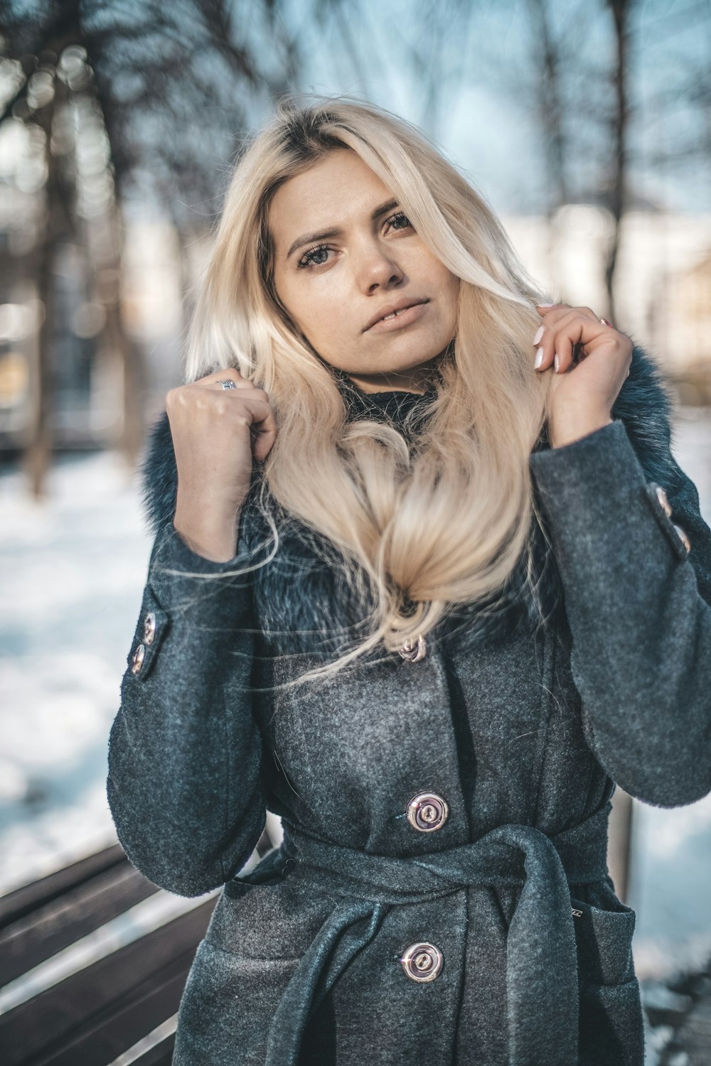 woman wearing gray trench coat in selective focus photography