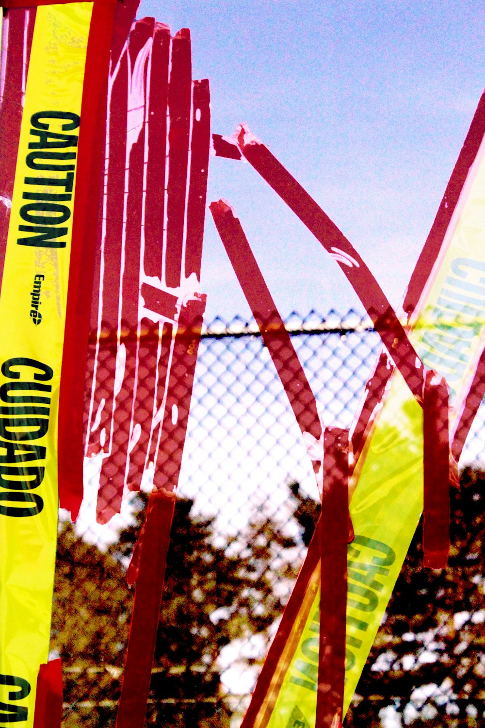 yellow Caution ribbon near metal fence