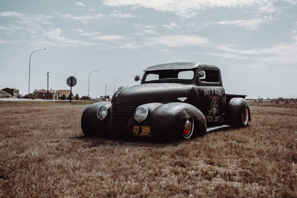 black customized beetle on brown grass field at daytime