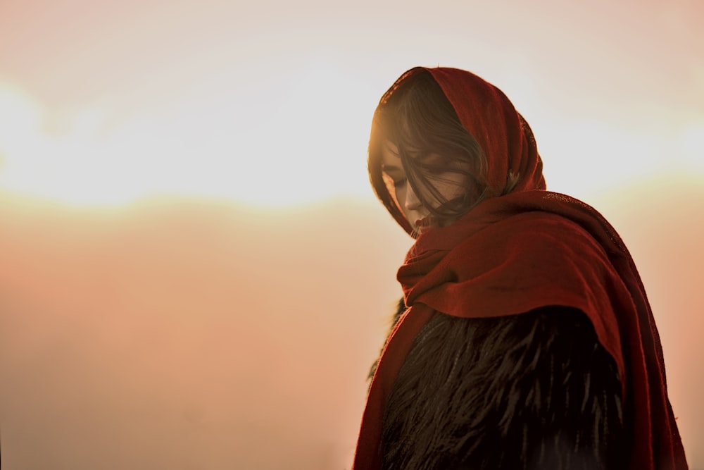 Frau mit rotem Kopftuch gegen die Sonne Foto