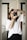 woman in white top looking through the camera peephole