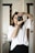 woman in white top looking through the camera peephole