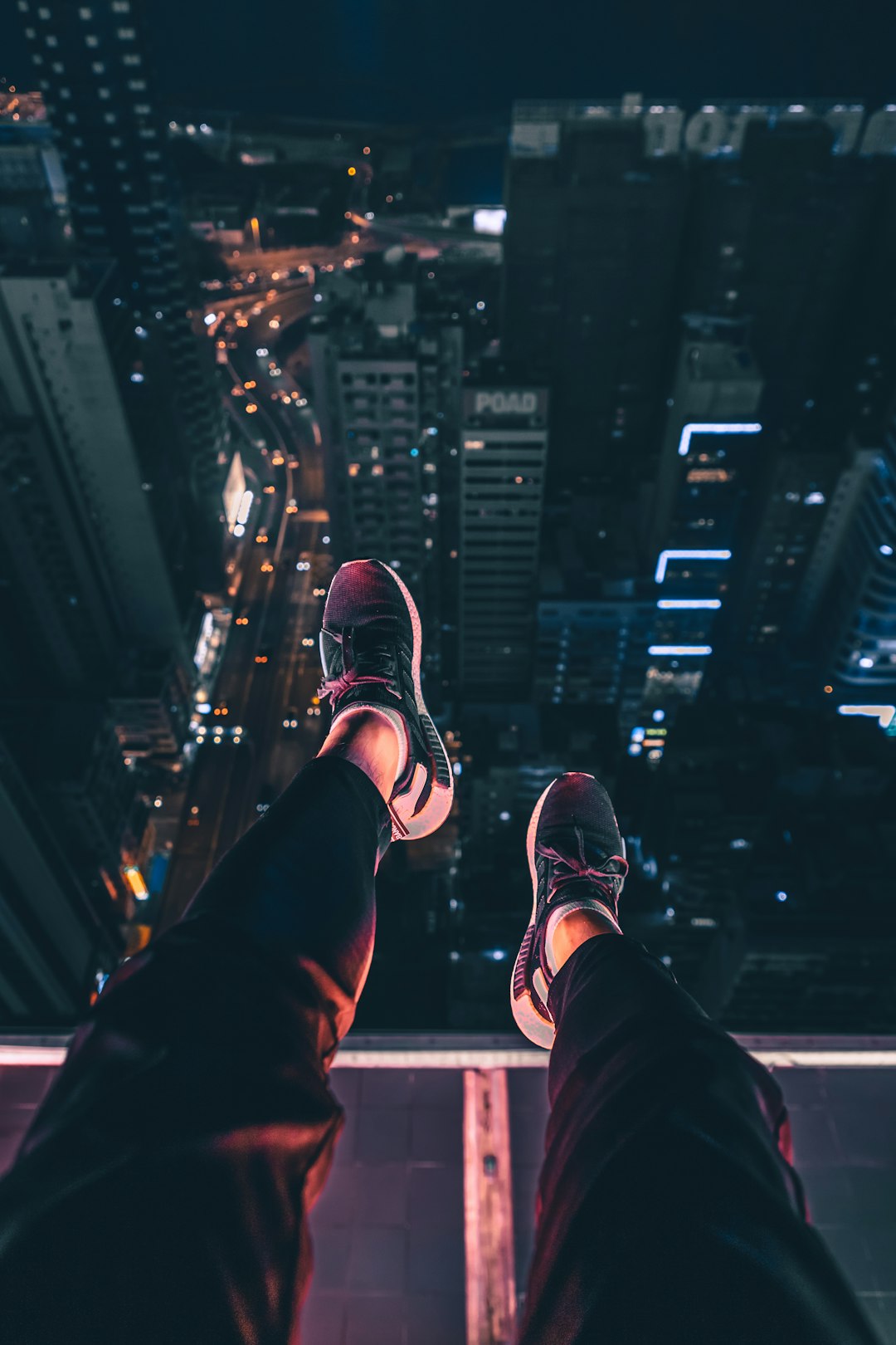 person sits at the edge of building