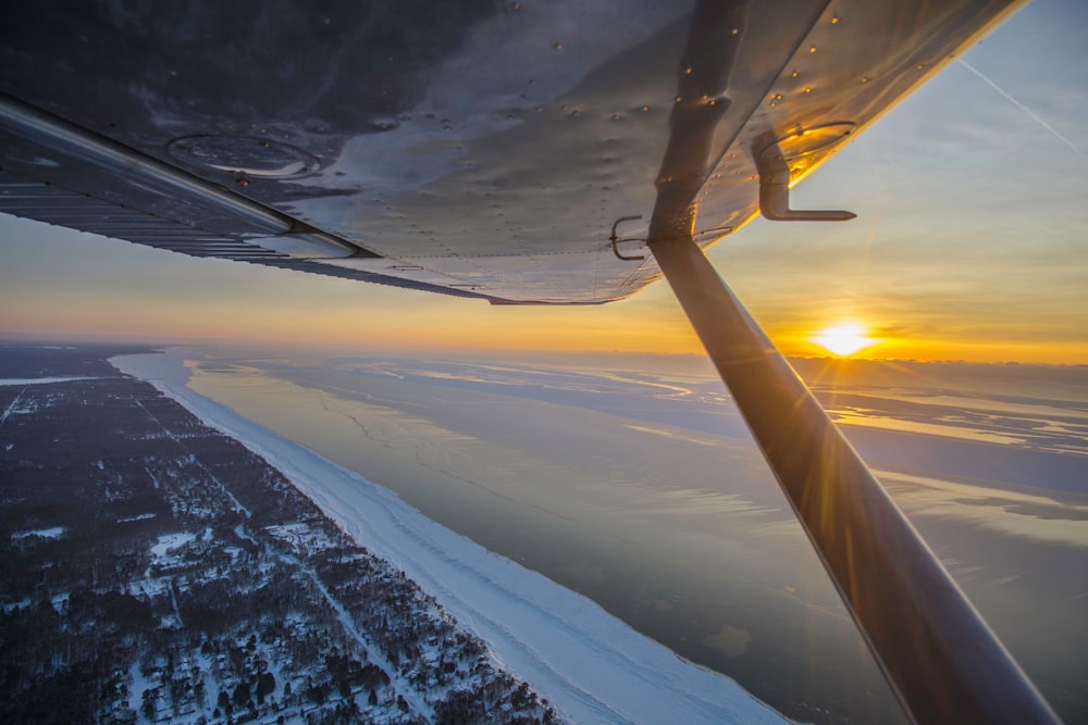 a view of the wing of a plane as the sun sets