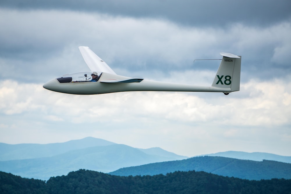 flying white X8 under cloudy skies during daytime