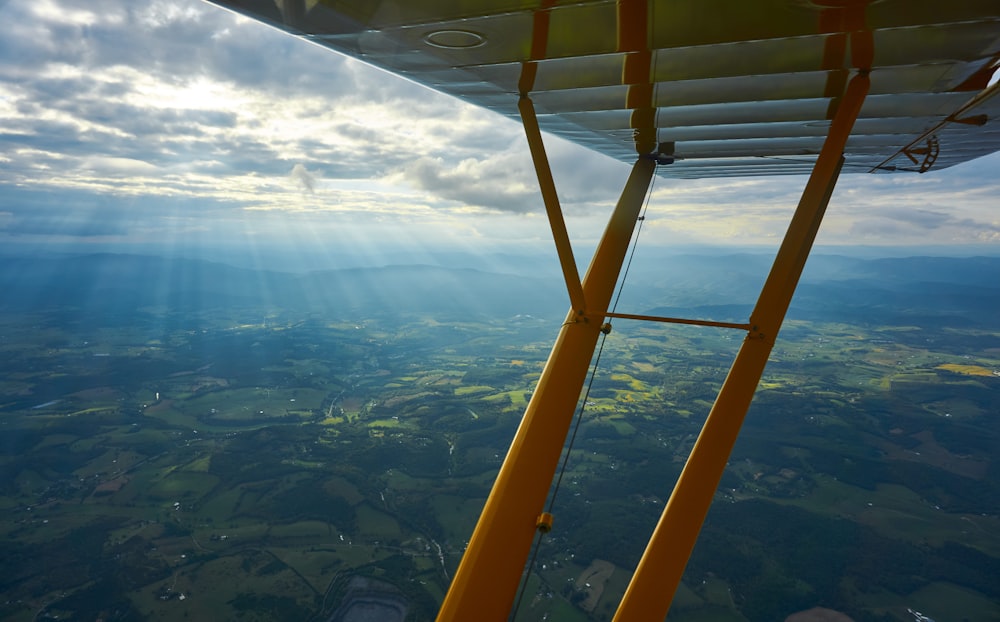 flying yellow plane wings during daytime