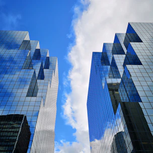 glass buildings under blue sky with clouds