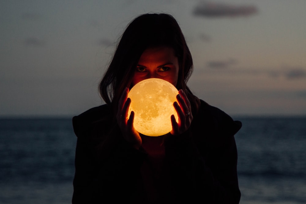 mujer sosteniendo lámpara de luna