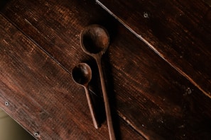 Close-up of a smooth oak wooden spoon with visible grain patterns resting on a rustic kitchen linen.