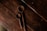 Close-up of a hand holding a finely crafted wooden spoon over a rustic kitchen counter.