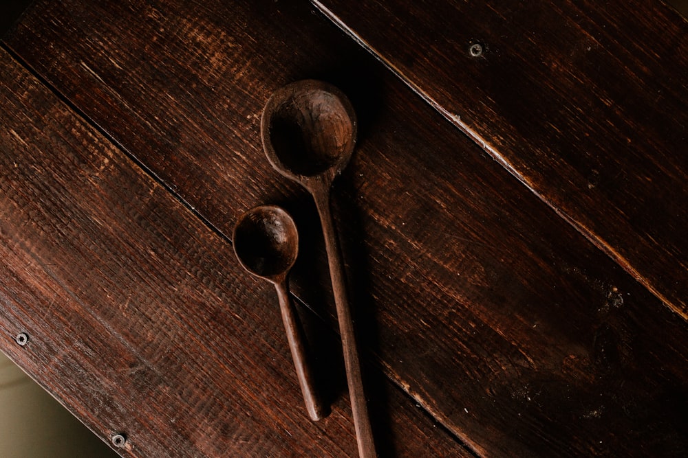 deux cuillères en bois marron sur une table en bois marron