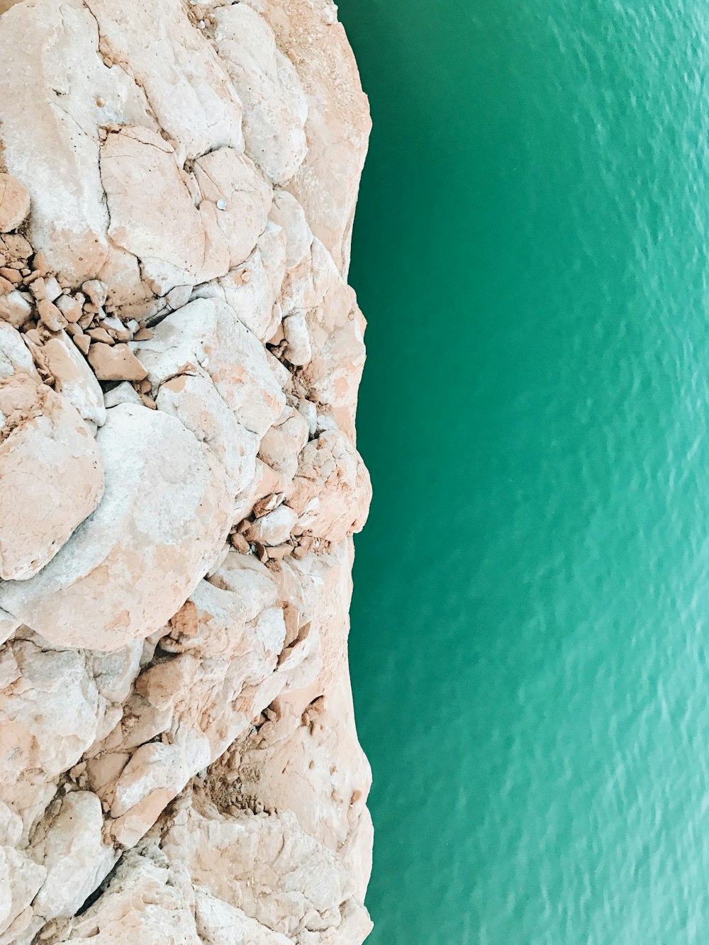 brown rock formation beside beach during daytime