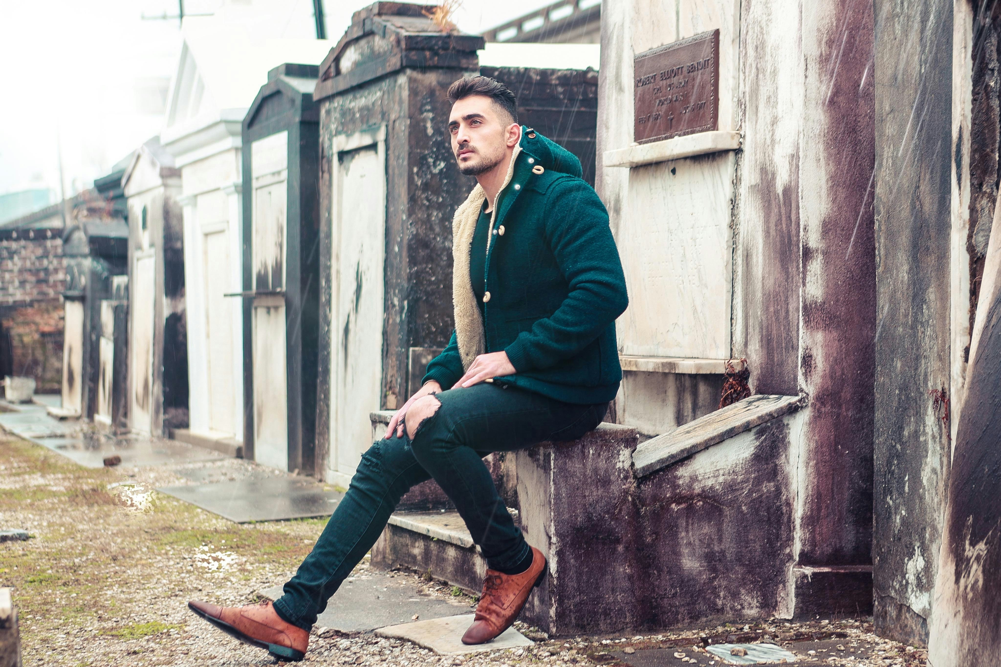 man sitting on concrete surface