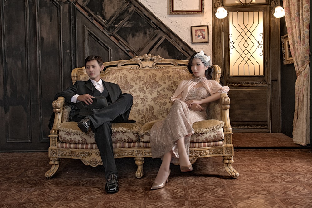 man and woman sitting on beige sofa