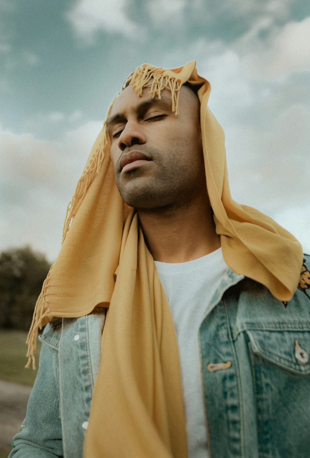 man closing eyes with scarf on his head