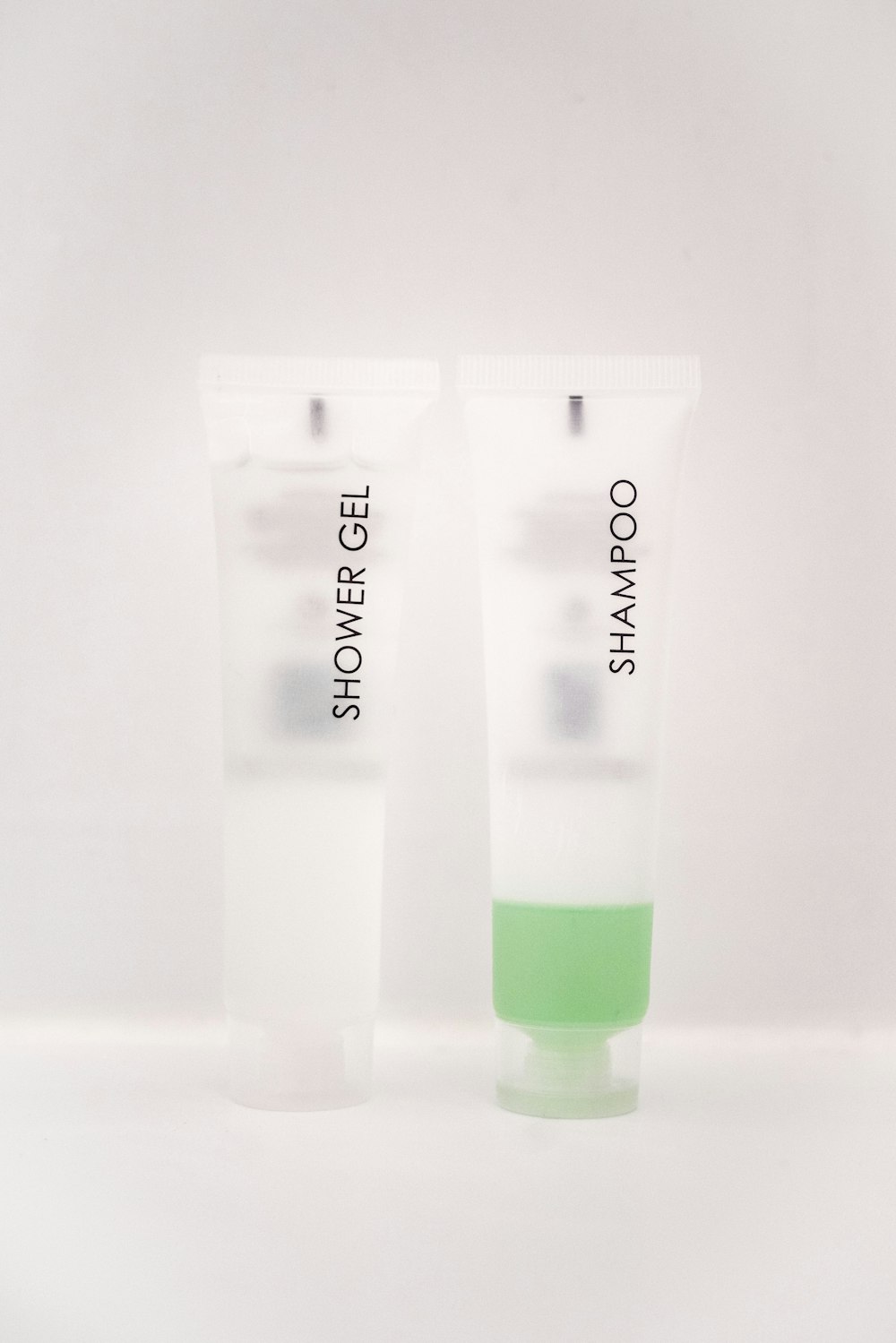 shower gel and shampoo soft-tube bottles on white surface