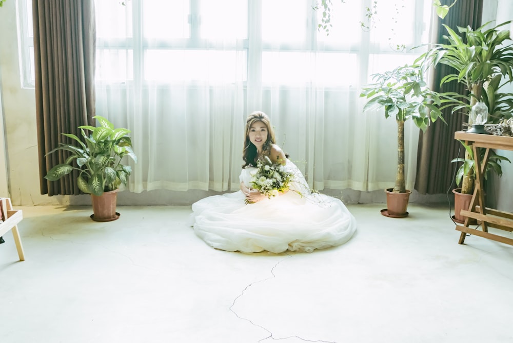 woman wearing wedding dress sitting on floor