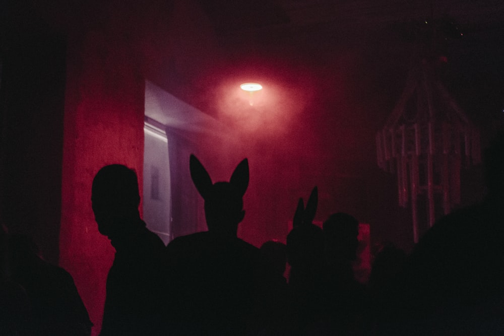 a group of people standing in front of a red light