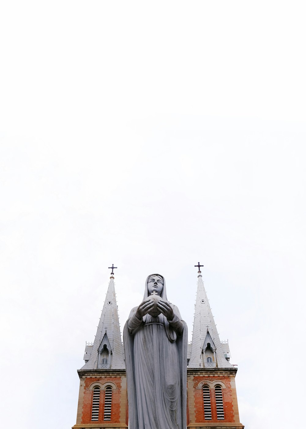 low-angle photography of religious sculpture outside cathedral during daytime