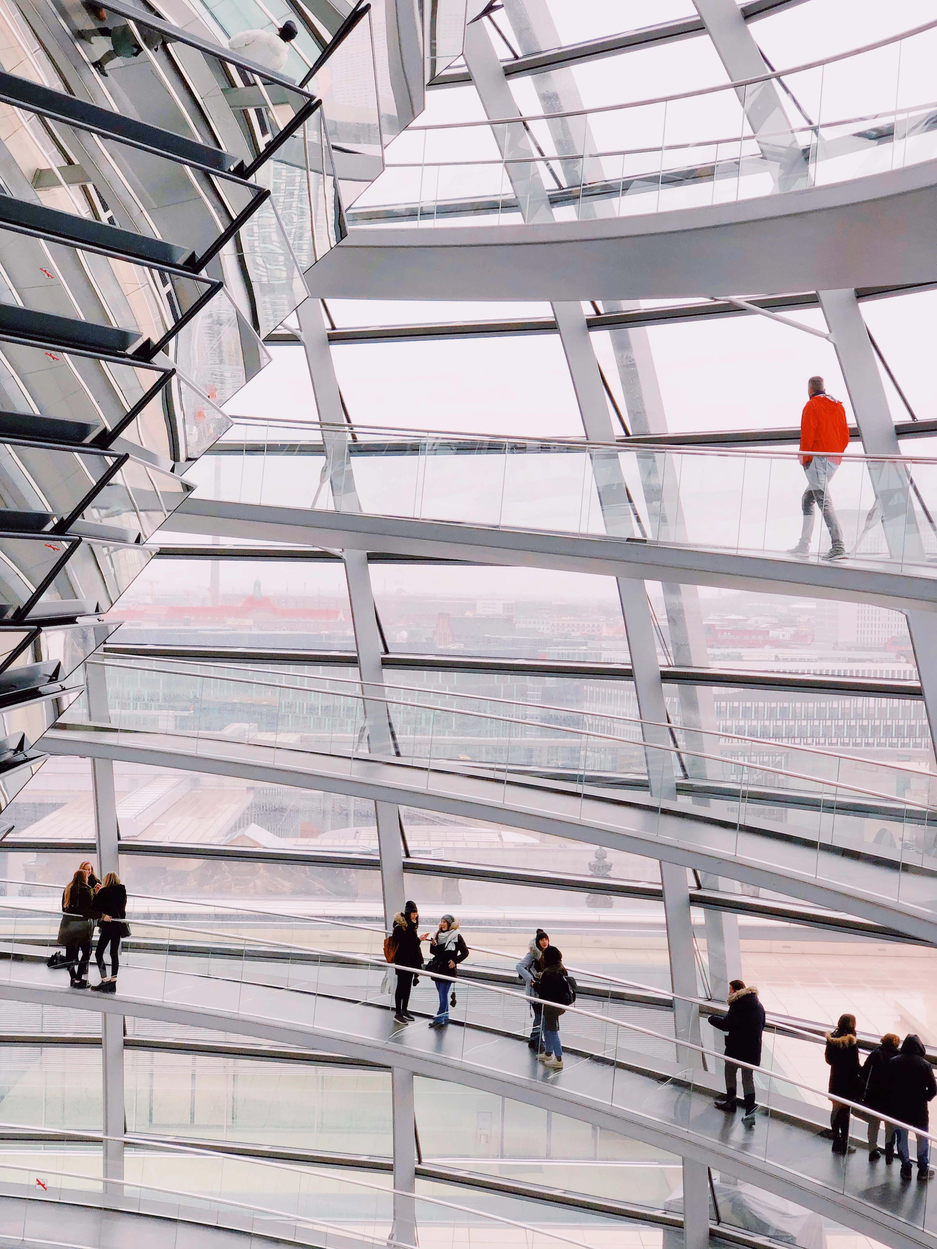 Visitors climbing the spiral ramp inside the glass dome of the Reichstag building in Berlin
