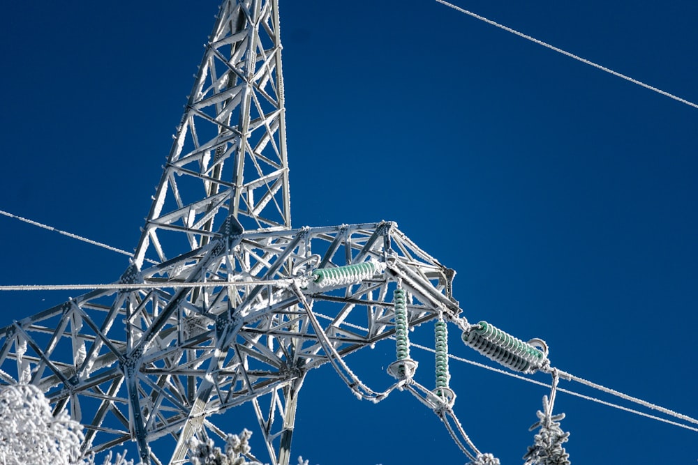 low-angle photography of electric tower under blue sky during daytime
