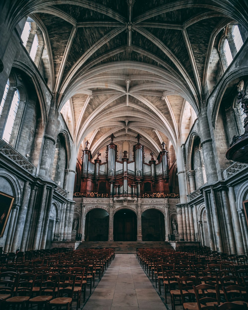 empty chairs inside concrete church during daytime