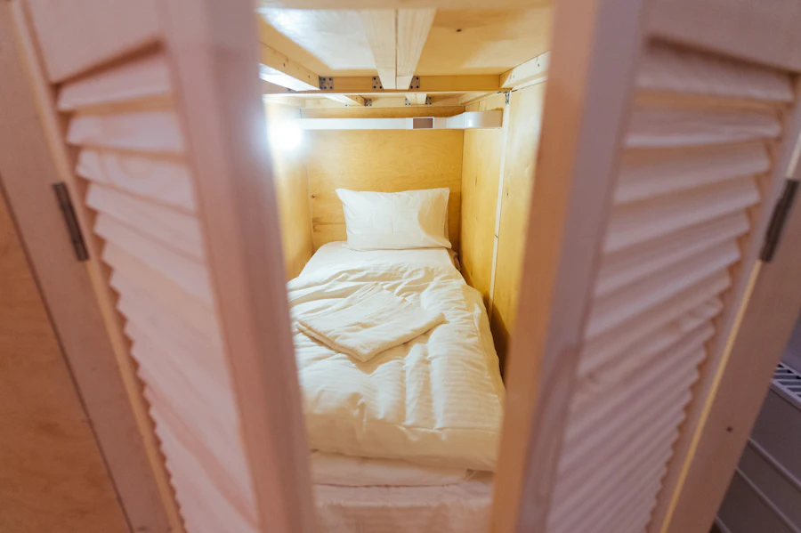 Interior of a NestPod Solo capsule with a white mattress and wood lining