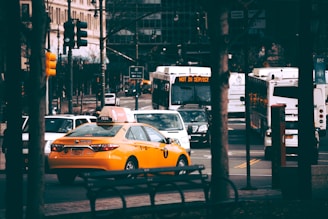 A busy New York City street filled with taxis and rideshare vehicles.