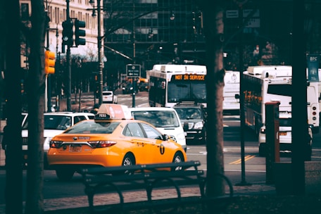 A busy New York City street filled with taxis and rideshare vehicles.