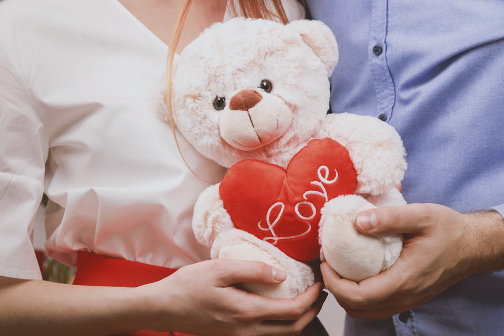 couple holding white bear plush toy