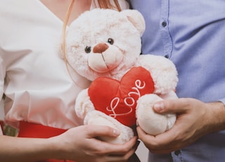 couple holding white bear plush toy