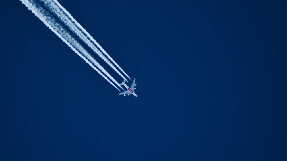 Foto aerea dell'aeroplano con scia durante il giorno