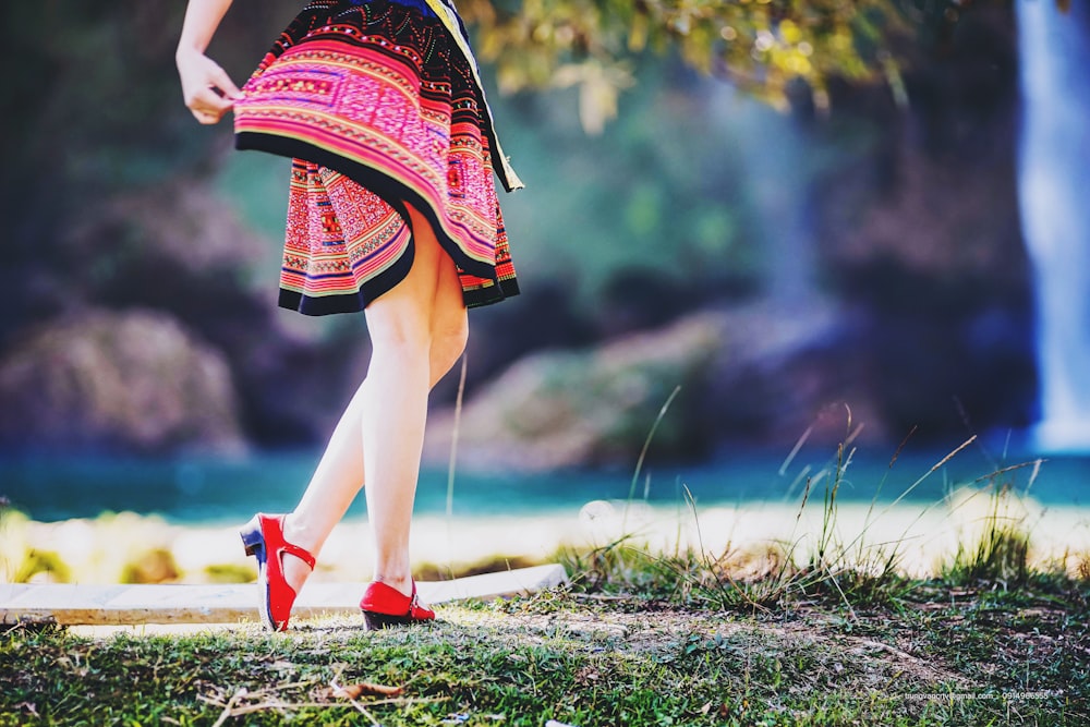 woman holds her skirt near waterfalls