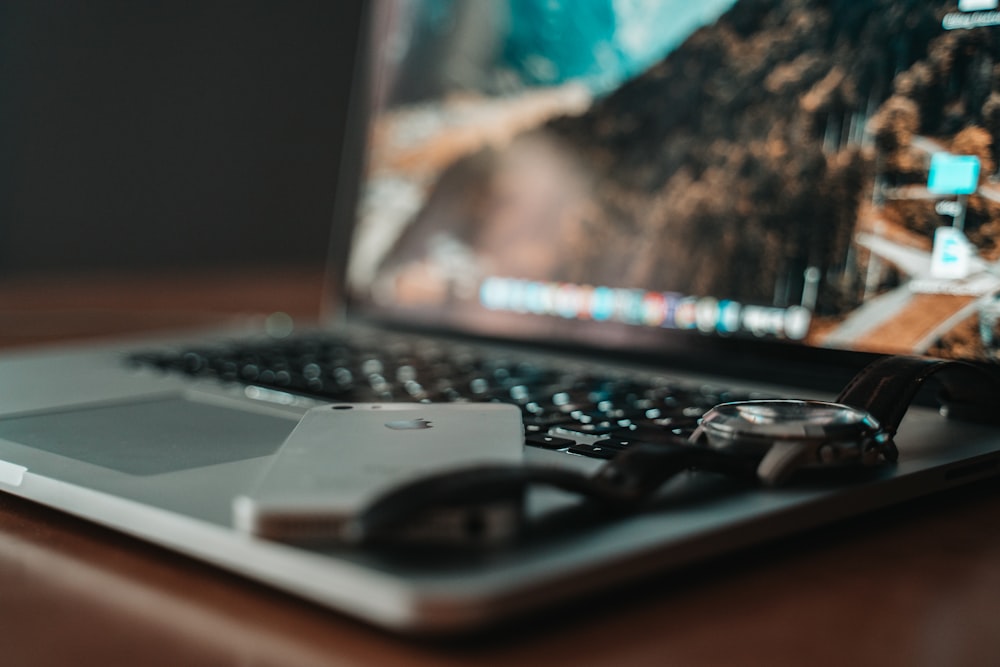 turned-on gray laptop computer on brown wooden surface