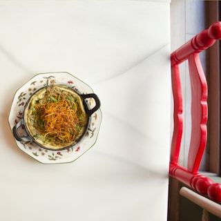 A close-up shot of a colorful dish garnished with fresh herbs on a rustic table.