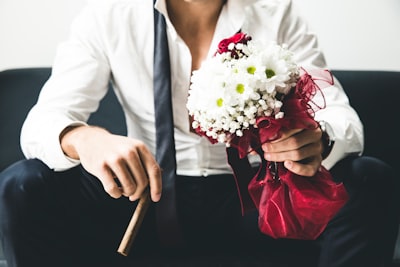 man holding bouquet of white flowers and brown tobacco handsome teams background