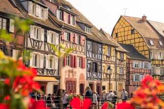 people walking beside assorted-color buildings during daytime
