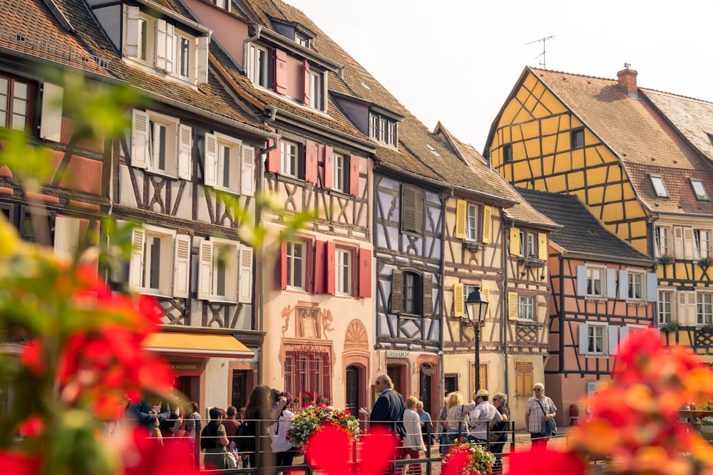 les gens qui marchent à côté de bâtiments aux couleurs variées pendant la journée