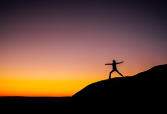 shillouette photo of person standing at the peak