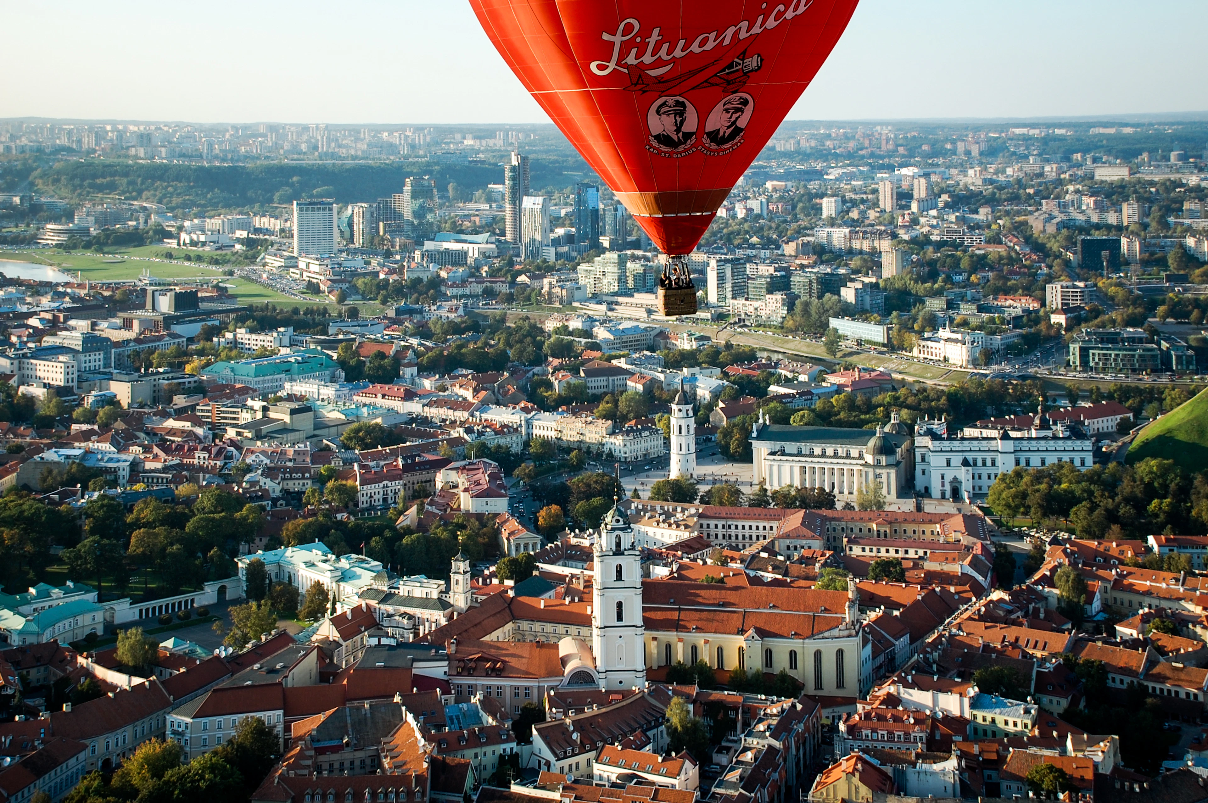 A hot-air balloon drifting over the red rooftops and church towers of Vilnius Old Town
