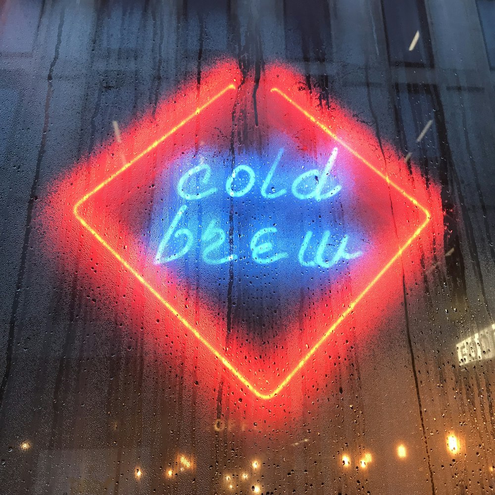 reflection of cold brew neon sign on glass wall