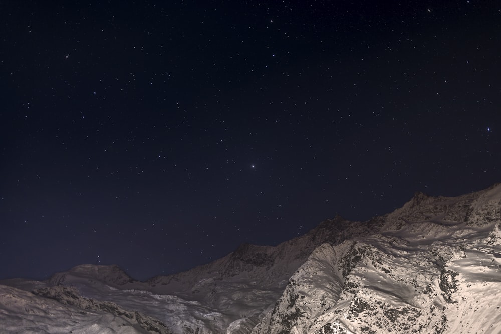 snow capped mountain under black sky