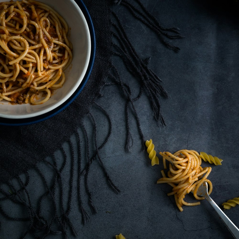 spaghetti on white and blue bowl