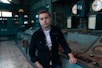 man wearing black button-up long-sleeved shirt standing inside room