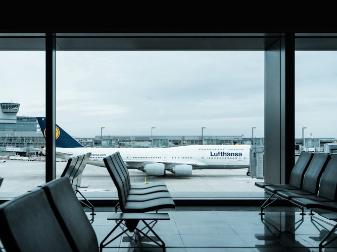Passengers boarding a plane through a jet bridge at an airport gate